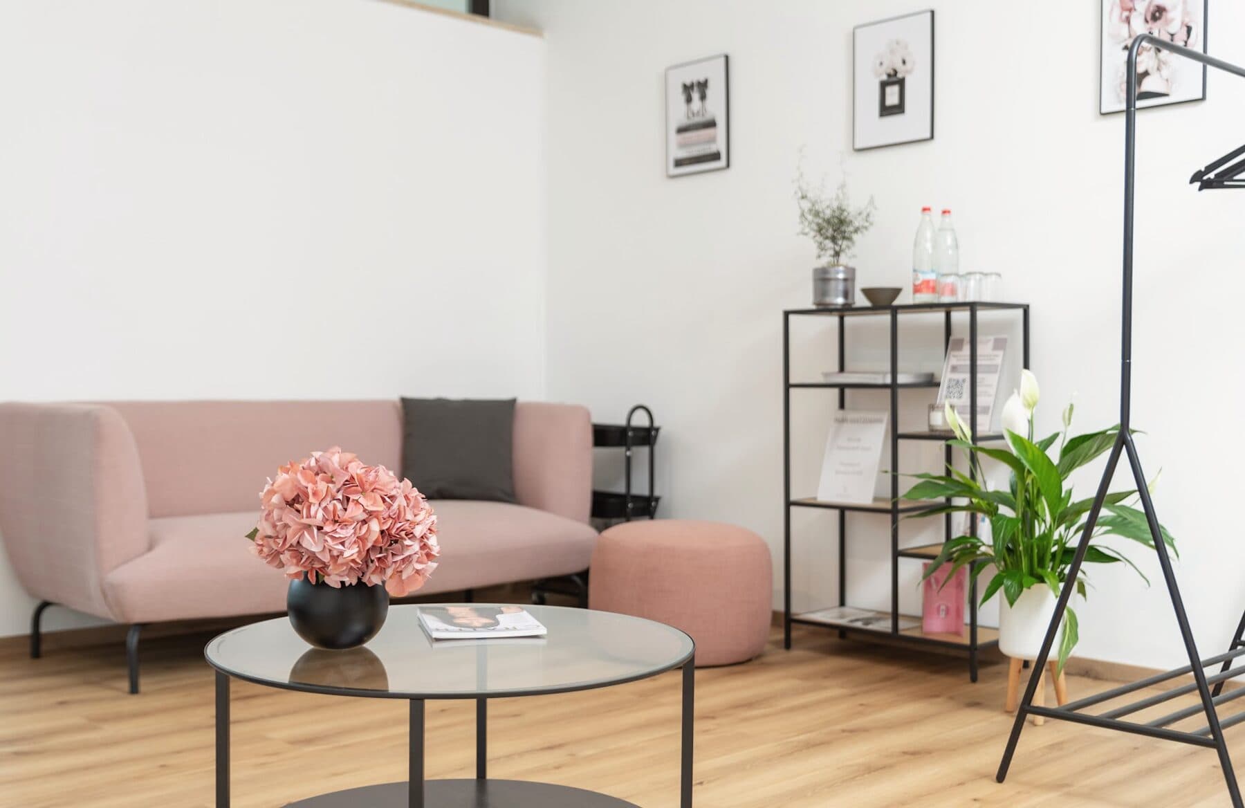 Wartebereich im Beautyloft mit altrosa Sofa, Hortensien und Produktregal
