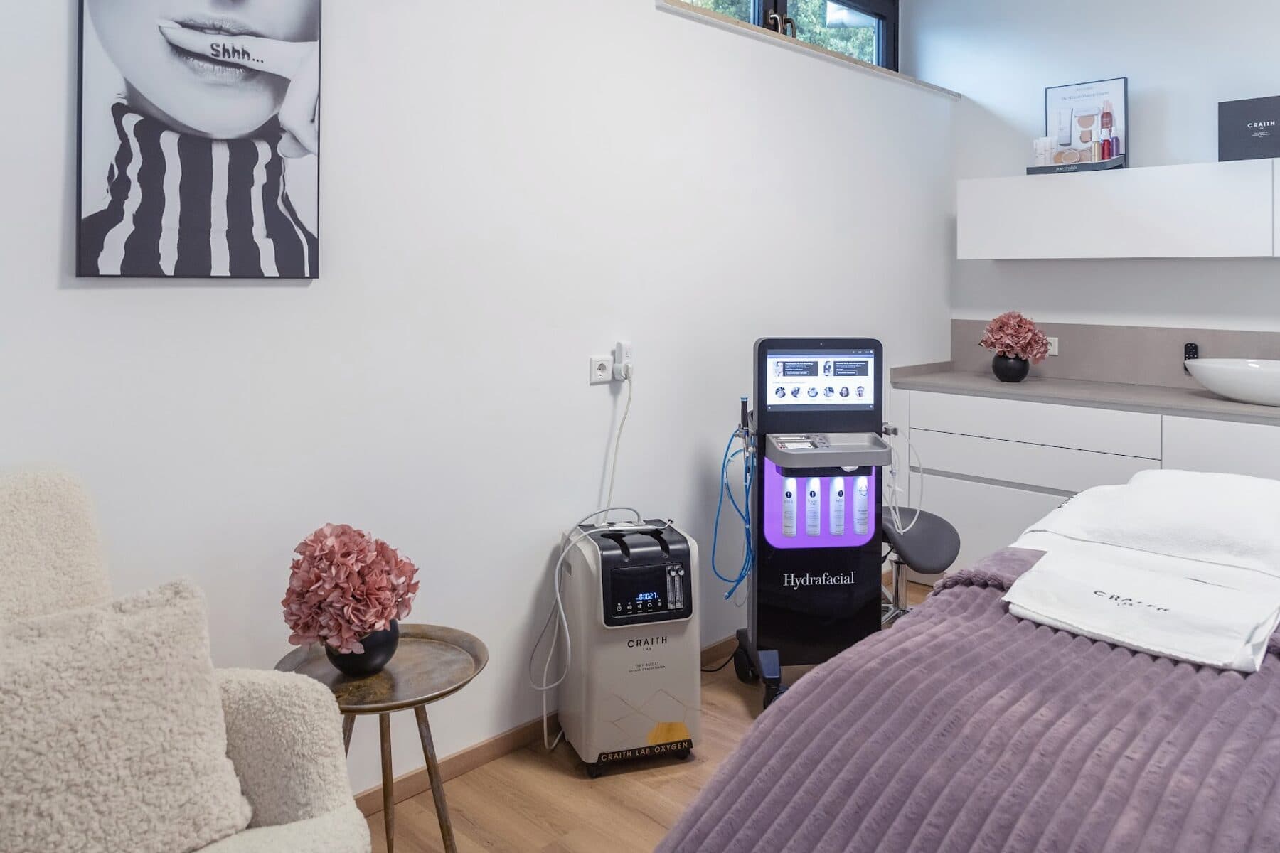 Behandlungsraum im Beautyloft mit dem HydraFacial-Gerät neben der Liege mit mauvefarbener Decke